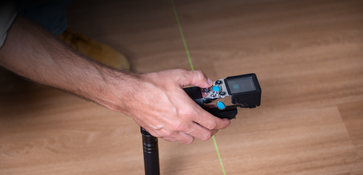 MILESEEY XTAPE1 projecting a green alignment laser across a floor