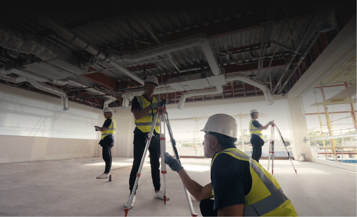 Workers using Mileseey S50C laser distance meters on tripods in an unfinished interior with exposed ductwork